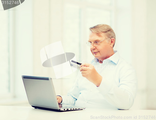 Image of old man with laptop and credit card at home