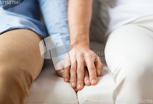 Image of close up of happy male gay couple holding hands