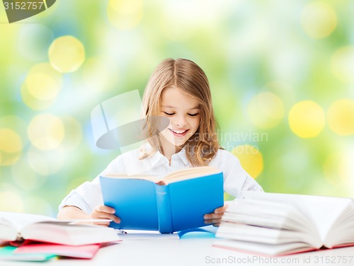 Image of happy student girl reading book at school
