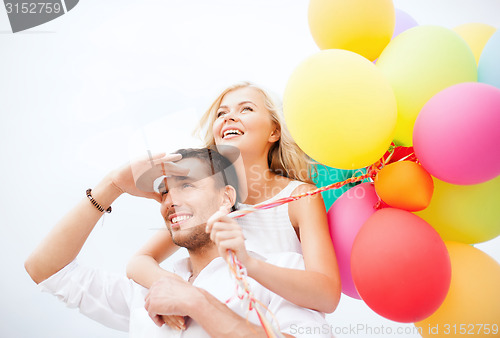 Image of couple with colorful balloons at seaside