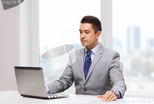 Image of businessman working with laptop in office