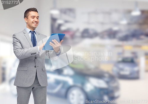 Image of happy businessman in suit with tablet pc