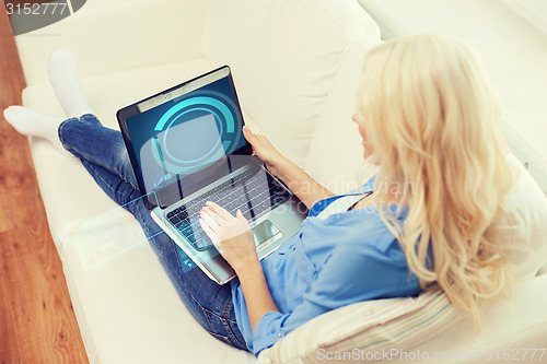 Image of smiling woman with laptop computer at home