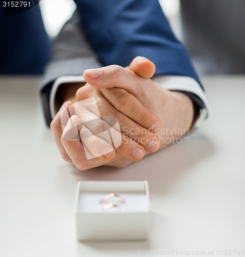 Image of close up of male gay couple and wedding rings