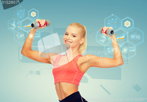 Image of smiling beautiful sporty woman with dumbbells