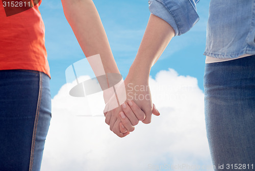 Image of close up of lesbian couple holding hands