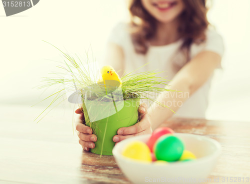 Image of close up of girl holding pot with green grass