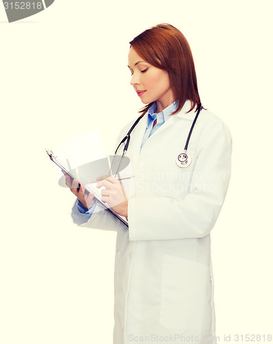 Image of smiling female doctor with clipboard