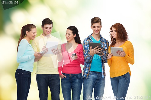 Image of group of teenagers with smartphones and tablet pc