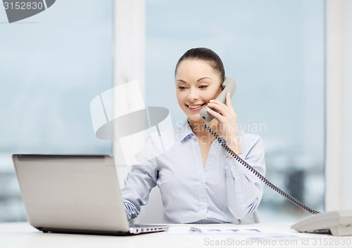 Image of businesswoman with phone, laptop and files