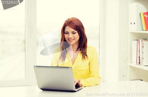 Image of smiling student with laptop computer at school