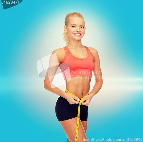 Image of smiling sporty woman with measuring tape