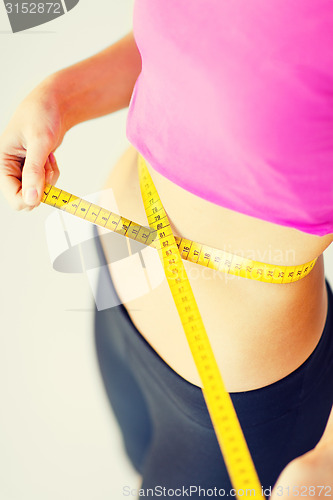Image of trained belly with measuring tape
