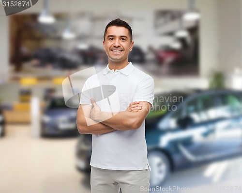 Image of smiling man in white t-shirt over  auto salon