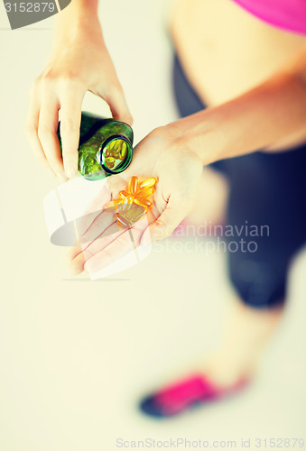 Image of woman hand with capsules