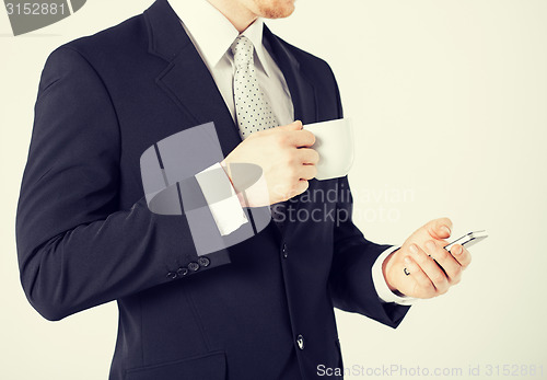 Image of man with smartphone and cup of coffee