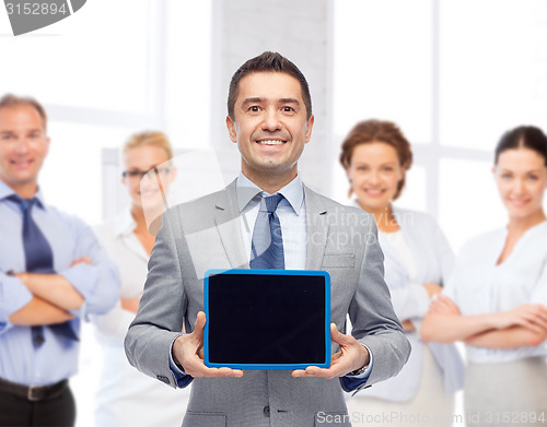 Image of happy businessman in suit showing tablet pc screen