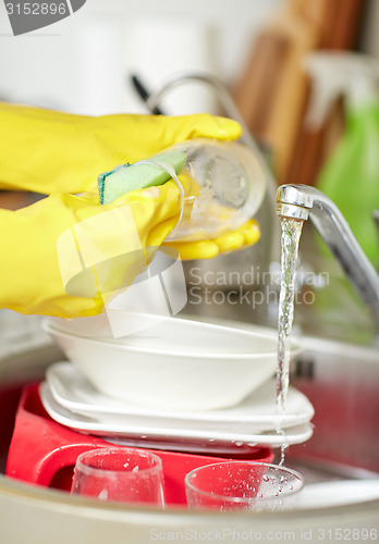 Image of close up of woman hands washing dishes in kitchen