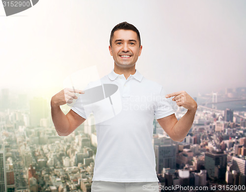 Image of smiling man in t-shirt pointing fingers on himself
