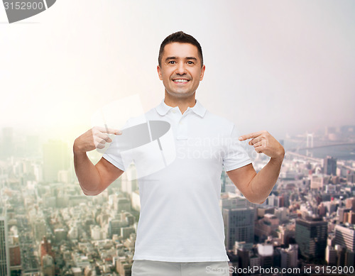 Image of smiling man in t-shirt pointing fingers on himself