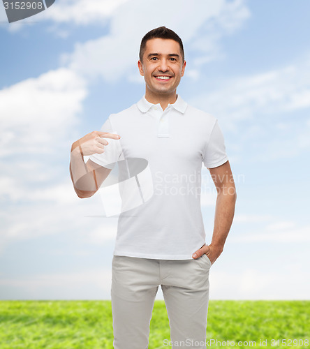 Image of smiling man in t-shirt pointing finger on himself