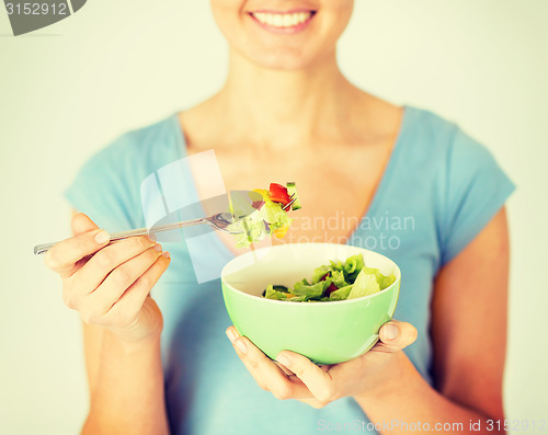 Image of woman eating salad with vegetables