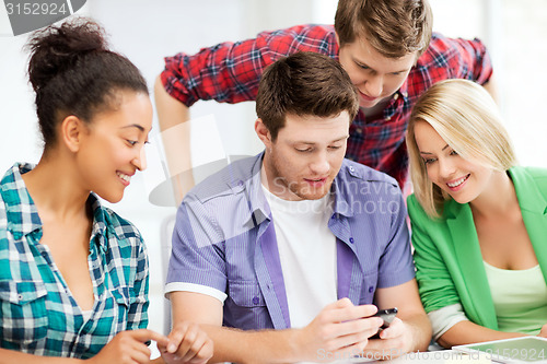 Image of students looking at smartphone at school
