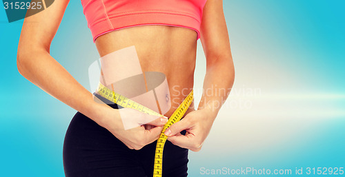 Image of close up of female hands measuring waist