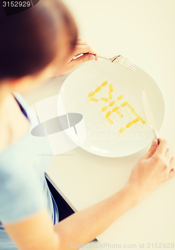 Image of woman with plate and meds