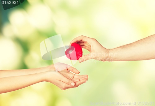 Image of woman and man hands with heart