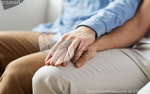 Image of close up of happy male gay couple holding hands