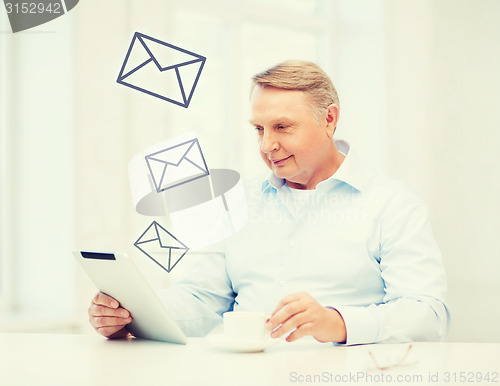 Image of old man with tablet pc computer at home