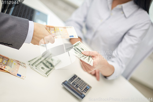 Image of close up of hands giving or exchanging money