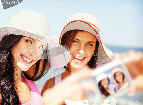 Image of girls taking self portrait on the beach