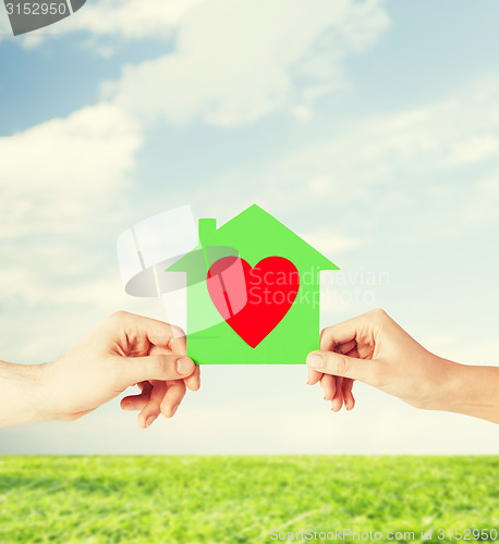 Image of couple hands holding green paper house