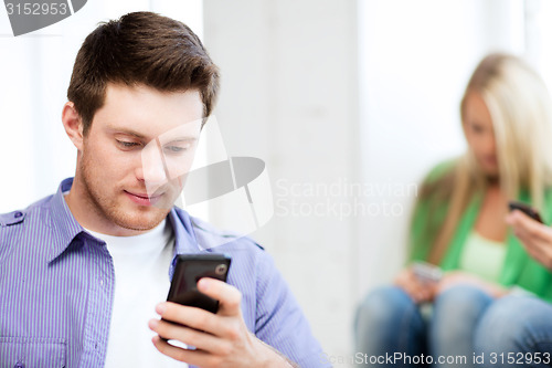 Image of student looking at phone and tiping