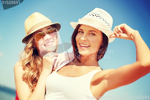 Image of girls in hats on the beach