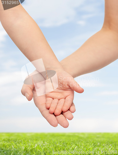 Image of close up of woman and little child hands together