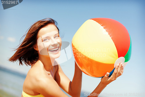 Image of girl in bikini playing ball on the beach