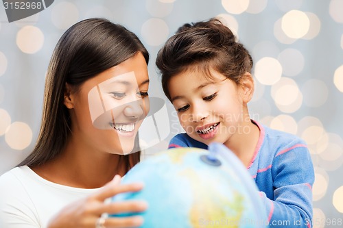 Image of happy mother and daughter with globe