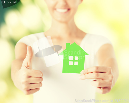 Image of woman hands holding green house
