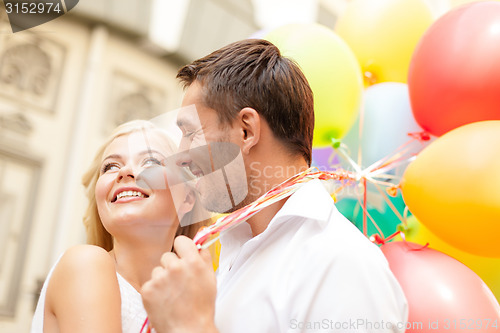 Image of happy couple with colorful balloons