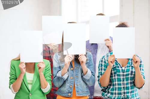 Image of students covering faces with blank papers