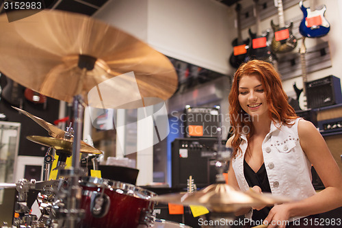 Image of smiling musician playing cymbals at music store