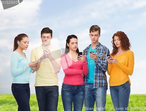 Image of group of serious teenagers with smartphones