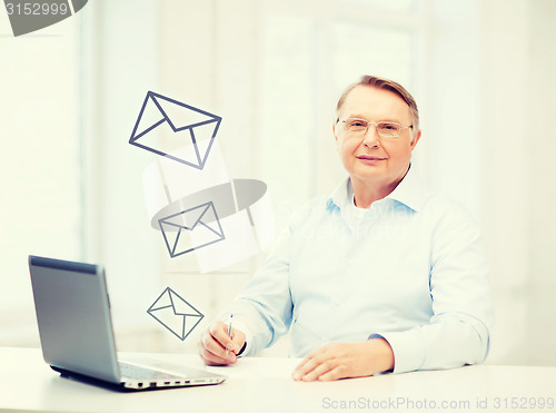 Image of old man in eyeglasses filling a form at home