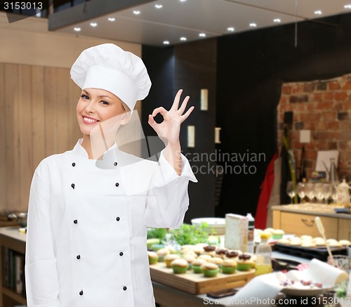 Image of smiling female chef showing ok hand sign