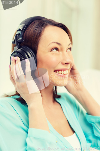 Image of smiling woman with headphones at home