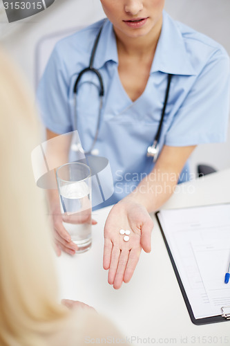 Image of close up of doctor giving pills to patient