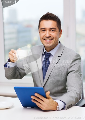 Image of smiling businessman with tablet pc and coffee cup